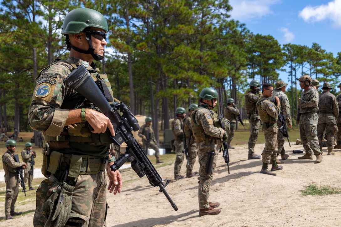 U.S. Marine Corps Lance Cpl. Luke Fitch, left, a native of Florida, is read his re-enlistment citation by Sgt. Kolton Brown, both riflemen with 2nd Battalion, 2nd Marine Regiment, alongside participating marines with Cuerpo de Infantreria de Marina (Chilean marine corps) during a multinational marksmanship range as part of exercise UNITAS 2025 at Marine Corps Base Camp Lejeune, North Carolina, Sept. 23, 2025. UNITAS, which is Latin for “unity,” was conceived in 1959 and has taken place annually since first conducted in 1960. This marks the 66th iteration of the world’s longest running annual multinational maritime exercise. (U.S. Marine Corps photo by Lance Cpl. Jack Labrador)