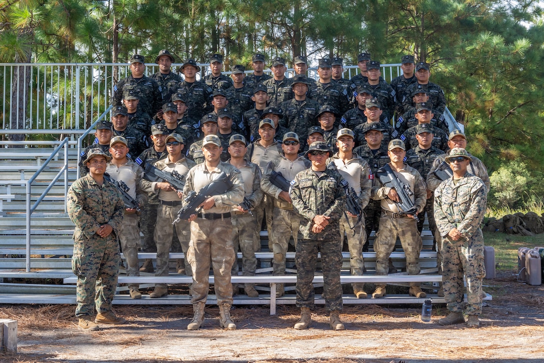 Marines with Batallon de Infanteria de Marine Fuerza Naval de El Salvador (El Salvadorian marine infantry brigade), and Infanteria De Marina Del Peru (Peruvian naval infantry) pose for a group photo with U.S. Marines with 2nd Battalion, 2nd Marine Regiment after a multinational marksmanship range as part of exercise UNITAS 2025 at Marine Corps Base Camp Lejeune, North Carolina, Sept. 23, 2025. UNITAS, which is Latin for “unity,” was conceived in 1959 and has taken place annually since first conducted in 1960. This marks the 66th iteration of the world’s longest running annual multinational maritime exercise. (U.S. Marine Corps photo by Lance Cpl. Jack Labrador)