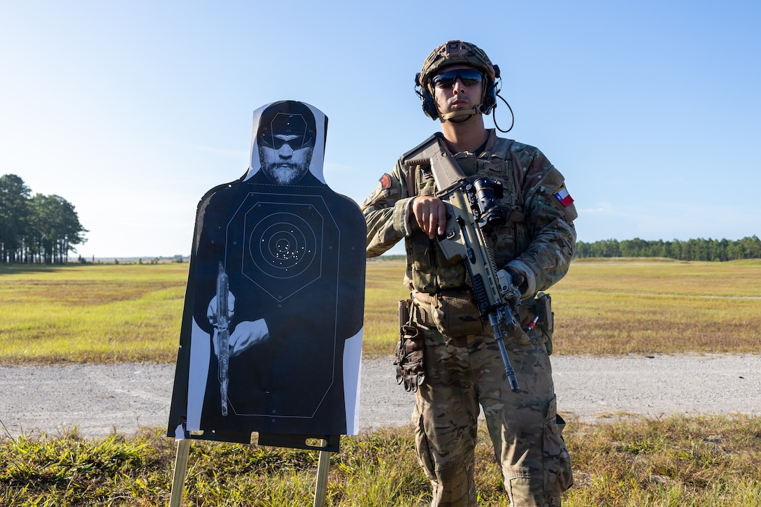 Cabo Primero Luis Cisterna, a marine with Cuerpo de Infanteria de Marina (Chilean marine corps) poses next to a target point he shot during a multinational marksmanship range as part of exercise UNITAS 2025 at Marine Corps Base Camp Lejeune, North Carolina, Sept. 23, 2025. UNITAS, which is Latin for “unity,” was conceived in 1959 and has taken place annually since first conducted in 1960. This marks the 66th iteration of the world’s longest running annual multinational maritime exercise. (U.S. Marine Corps photo by Lance Cpl. Jack Labrador)