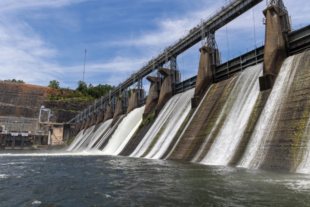 Water cascades under the spill gates at the John Hollis Bankhead Dam on June 11, 2024, at Bankhead Lake, Alabama. This image highlights the dam's role in controlling water flow and supporting water management and navigation on the Black Warrior River.