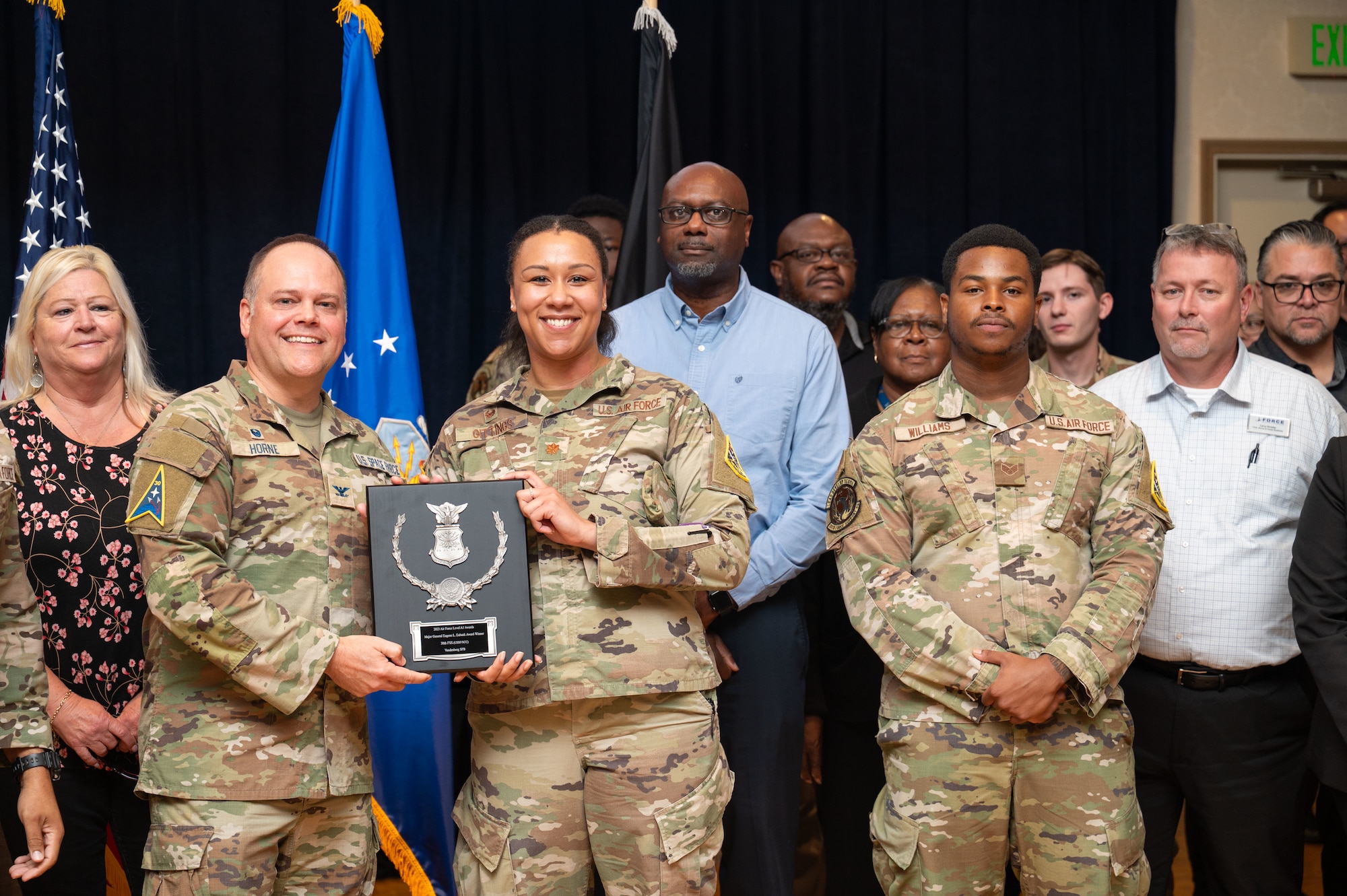 Group of people stand and smile for a photo.
