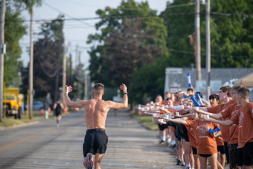 A participant in the full marathon runs by a group of volunteers during the 29th Annual Air Force Marathon on September 20, 2025.