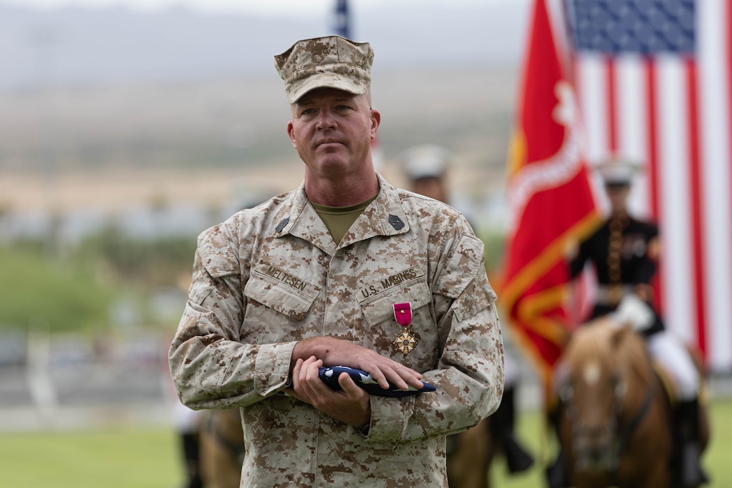 U.S. Marine Corps Sgt. Maj. Ryan W. Meltesen, a Wisconsin native, the incoming sergeant major of Marine Air Ground Task Force Training Command, Marine Corps Air Ground Combat Center, after receiving Old Glory during a relief and appointment ceremony at Lance Cpl. Torrey L. Gray field at MCAGCC, Twentynine Palms, California, Aug. 28, 2025. Meltesen relinquished command of MAGTFTC, MCAGCC, to Sgt. Maj. Roberto C. Lopez the incoming sergeant major of MAGTFTC, MCAGCC, a tradition symbolizing the transfer of authority, responsibility and accountability of the Marines and sailors under his charge. (U.S. Marine Corps photo by Lance Cpl. Parker Peichel)