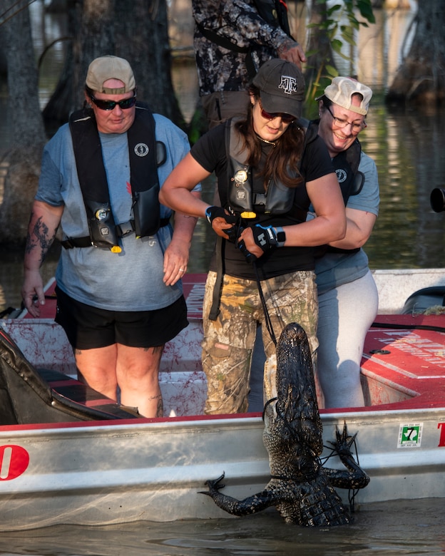 US Navy veteran Sarah Stewart, pulls her alligator into the boat during the 2025 B.A. Steinhagen Veterans Alligator Hunt, sponsored by the U.S. Army Corps of Engineers' Fort Worth District, the Piney Woods Service Association, and Texas Parks and Wildlife, held at BA Steinhagen Lake, 13 Sept. 2025. There were four hunt tags given to the four veteran hunters, with three total alligators harvested.
