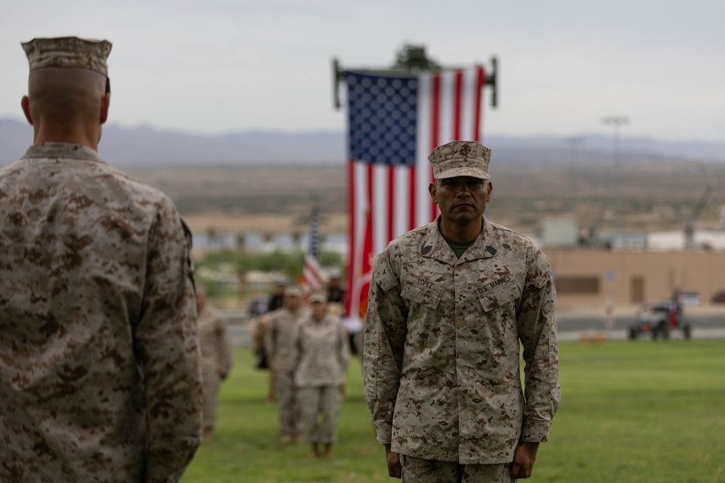 U.S. Marine Corps Sgt. Maj. Roberto C. Lopez, the incoming sergeant major of Marine Air Ground Task Force Training Command, Marine Corps Air Ground Combat Center, prepares to receive the non-commissioned officer sword, during a relief and appointment ceremony at Lance Cpl. Torrey L. Gray field at MCAGCC, Twentynine Palms, California, Aug. 28, 2025. Sgt. Maj. Ryan W. Meltesen, a Wisconsin native, the outgoing sergeant major of MAGTFTC, MCAGCC, relinquished command of MAGTFTC, MCAGCC, to Lopez, a tradition symbolizing the transfer of authority, responsibility and accountability of the Marines and sailors under his charge. (U.S. Marine Corps photo by Lance Cpl. Parker Peichel)