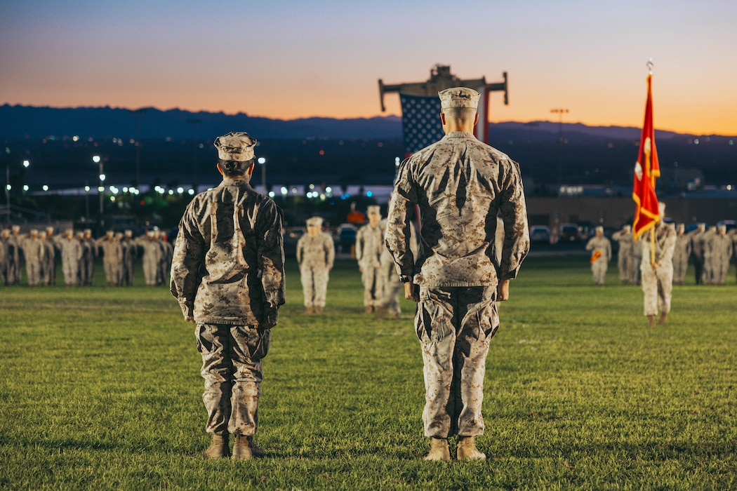 U.S. Marine Corps Col. Misty Posey, left, incoming commanding officer of Headquarters Battalion, Marine Air Ground Task Force Training Command, Marine Corps Air Ground Combat Center, and Lt. Col. Nathan Rollins, outgoing commanding officer of HQBN, MAGTFTC, MCAGCC, stand at attention during a change of command ceremony at Lance Cpl. Torrey Grey Field, MCAGCC, Twentynine Palms, California, Sept. 15, 2025. This change of command ceremony represents the official passing of authority from the outgoing commanding officer, Lt. Col. Nathan Rollins, to the incoming commanding officer, Col. Misty Posey. (U.S. Marine Corps photo by Lance Cpl. Gracelyn Hanson)