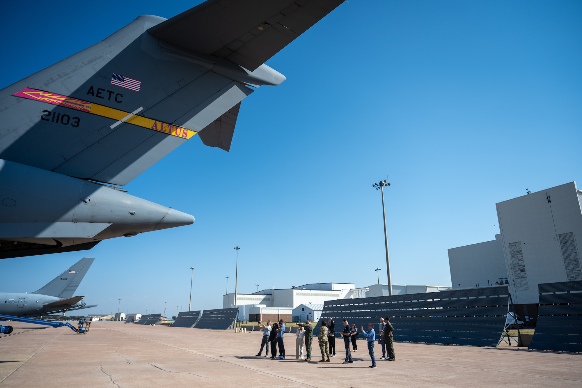 U.S. Air Force Air Education and Training Command civic leaders stand under the tail of a C-17 Globemaster III aircraft during a tour at Altus Air Force Base (AFB), Oklahoma, Sept. 16, 2025. The tour was part of a visit by McConnell AFB leadership to understand the critical role Altus has in training Airmen prior to their arrival at other bases. (U.S. Air Force photo by Airman 1st Class Nathan Langston)