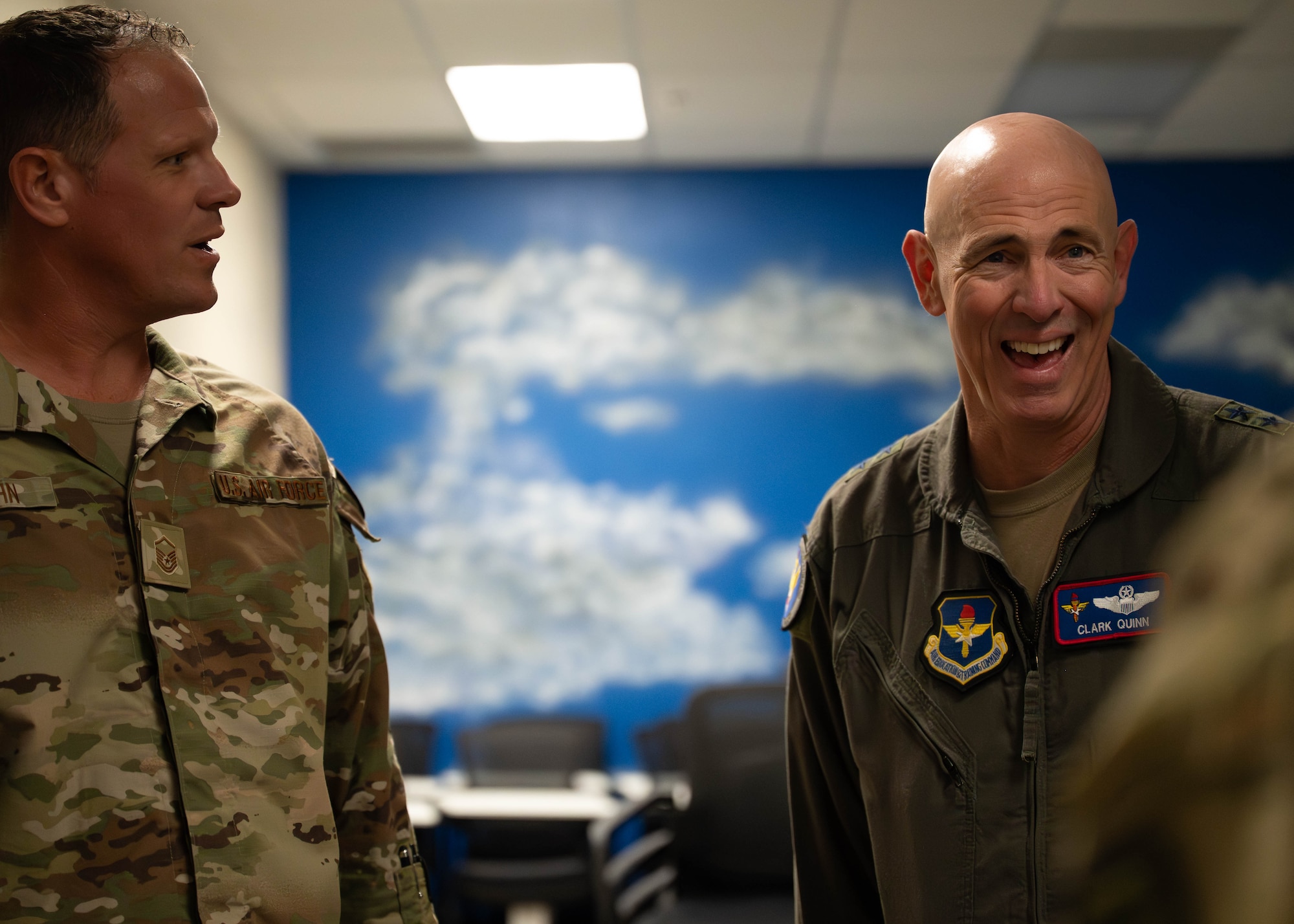 U.S. Air Force Maj. Gen. Clark Quinn (right), Air Education and Training Command deputy commander, and Master Sgt. Justin Vaughn (left), 56th Force Support Squadron Airman Leadership School commandant, talks to Airmen while touring a squadron work center at the library, Sept. 16, 2025, at Luke Air Force base, Arizona.