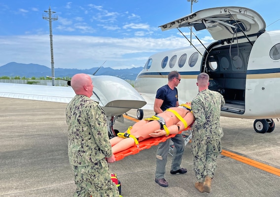 NAGASAKI, Japan (Sept. 23, 2025) – Lt. Alexander Johnson and Hospital Corpsman 3rd Class Evan Talcott, assigned to U.S. Navy Medicine Readiness and Training Command (USNMRTC) Yokosuka, transfer a simulated casualty to a C-12 Huron aircraft at Nagasaki Airport during a mass casualty drill. The patient was prepared by a U.S. Navy Medicine Readiness and Training Unit (USNMRTU) Sasebo medical crew for medical evacuation to Naval Air Facility (NAF) Atsugi. (U.S. Navy photo by Lt. Cmdr. Matthew Thomas)