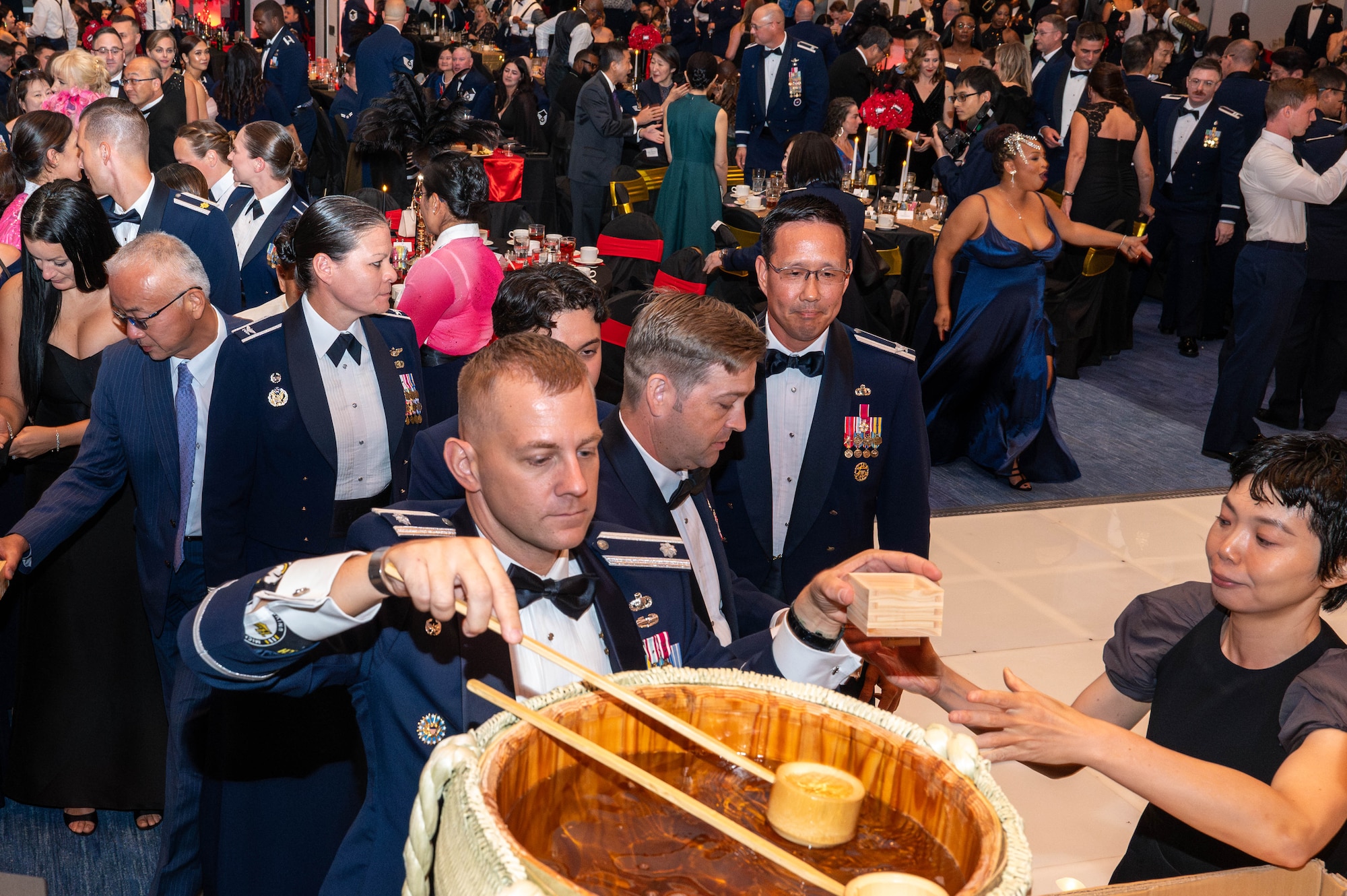 Team Yokota members fill cups with sake.