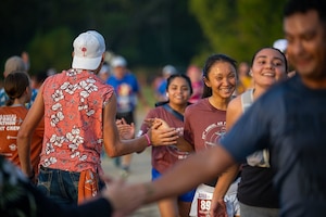 A participant in the full marathon runs by a group of volunteers during the 29th Annual Air Force Marathon on September 20, 2025.