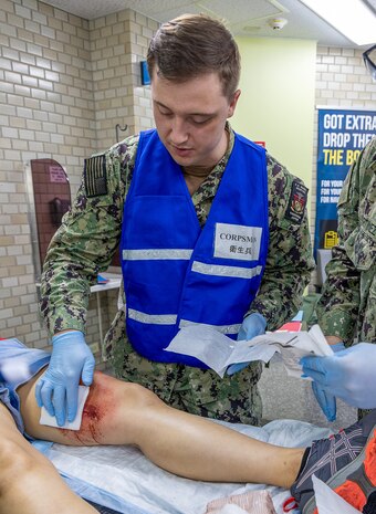 YOKOSUKA, Japan (Sept. 23, 2025) – A hospital corpsman assigned to U.S. Navy Medicine Readiness and Training Command (USNMRTC) Yokosuka attends to a simulated casualty in the delayed treatment area during a mass casualty drill. The exercise evaluated the command’s ability to triage, stabilize and transport patients during a large-scale crisis. (U.S. Navy photo by Daniel Taylor/USNMRTC Yokosuka Public Affairs)