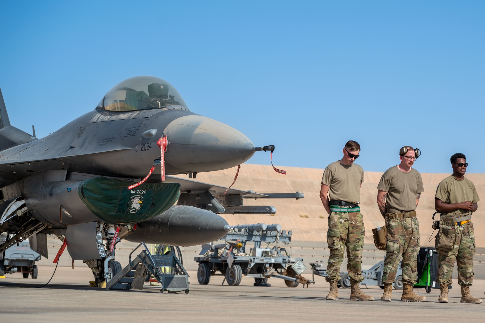 U.S. Air Force Senior Airman Logan Millman, Staff Sgt. William Taylor and Senior Airman Dimitri Rojas, all weapons load crew members assigned to the 555th Expeditionary Fighter Generation Squadron, take a moment to compose their thoughts and prepare before facing off in a load competition.
