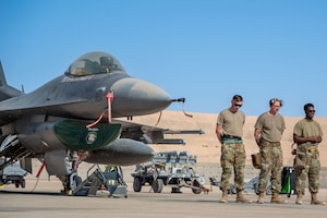 U.S. Air Force Senior Airman Logan Millman, Staff Sgt. William Taylor and Senior Airman Dimitri Rojas, all weapons load crew members assigned to the 555th Expeditionary Fighter Generation Squadron, take a moment to compose their thoughts and prepare before facing off in a load competition.