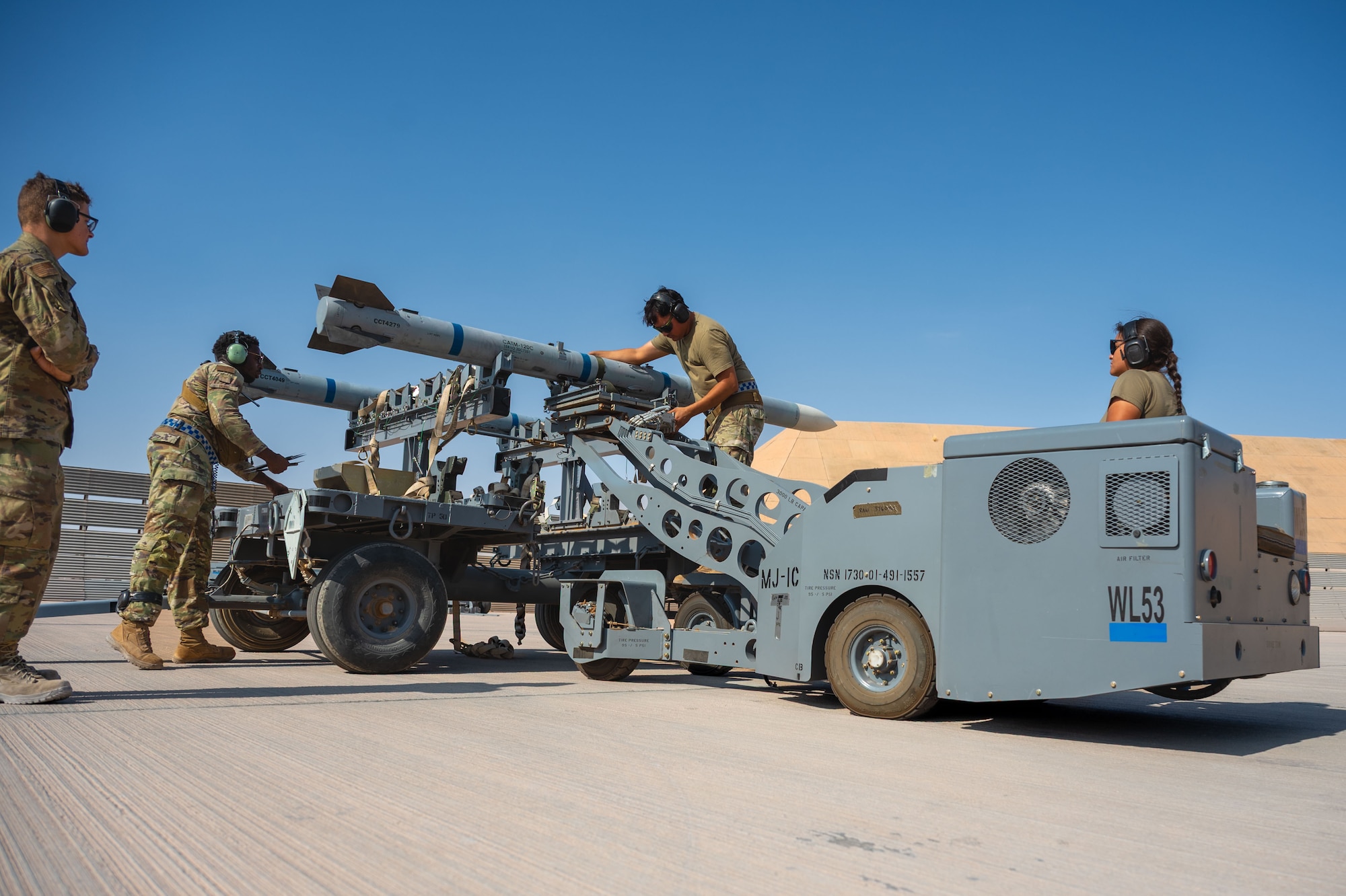 U.S. Air Force Airmen transport an AIM-120 to load onto an F-16 Fighting Falcon during a load competition.