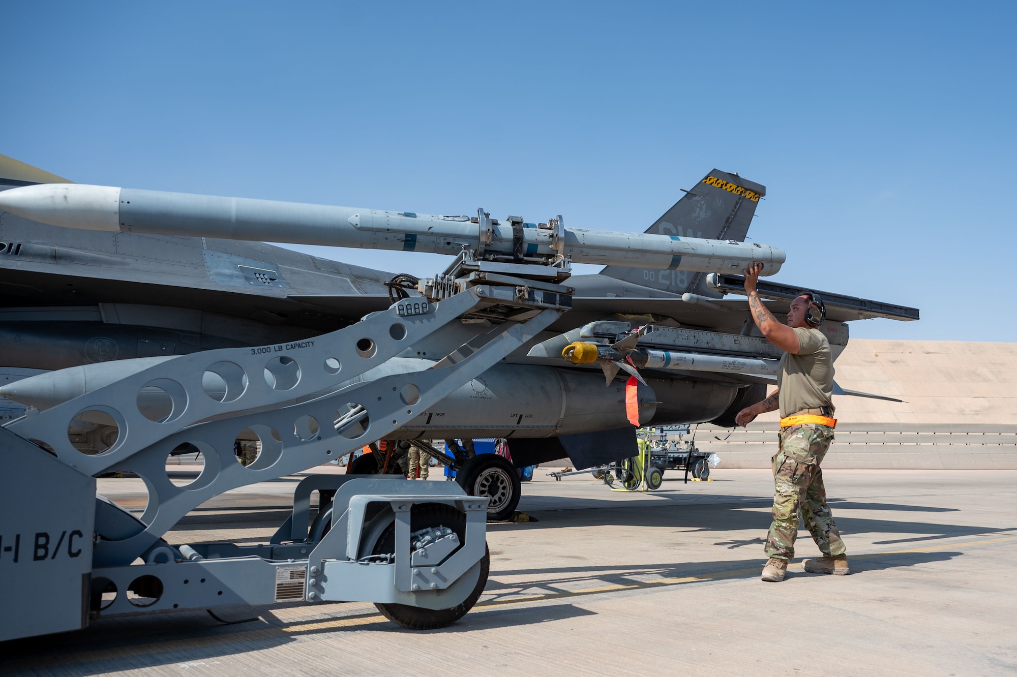 U.S. Air Force Joemari Lamorena, 79th Expeditionary Fighter Generation Squadron weapons load crew chief, guides an AIM-120 onto a LAU-129 during a load competition.