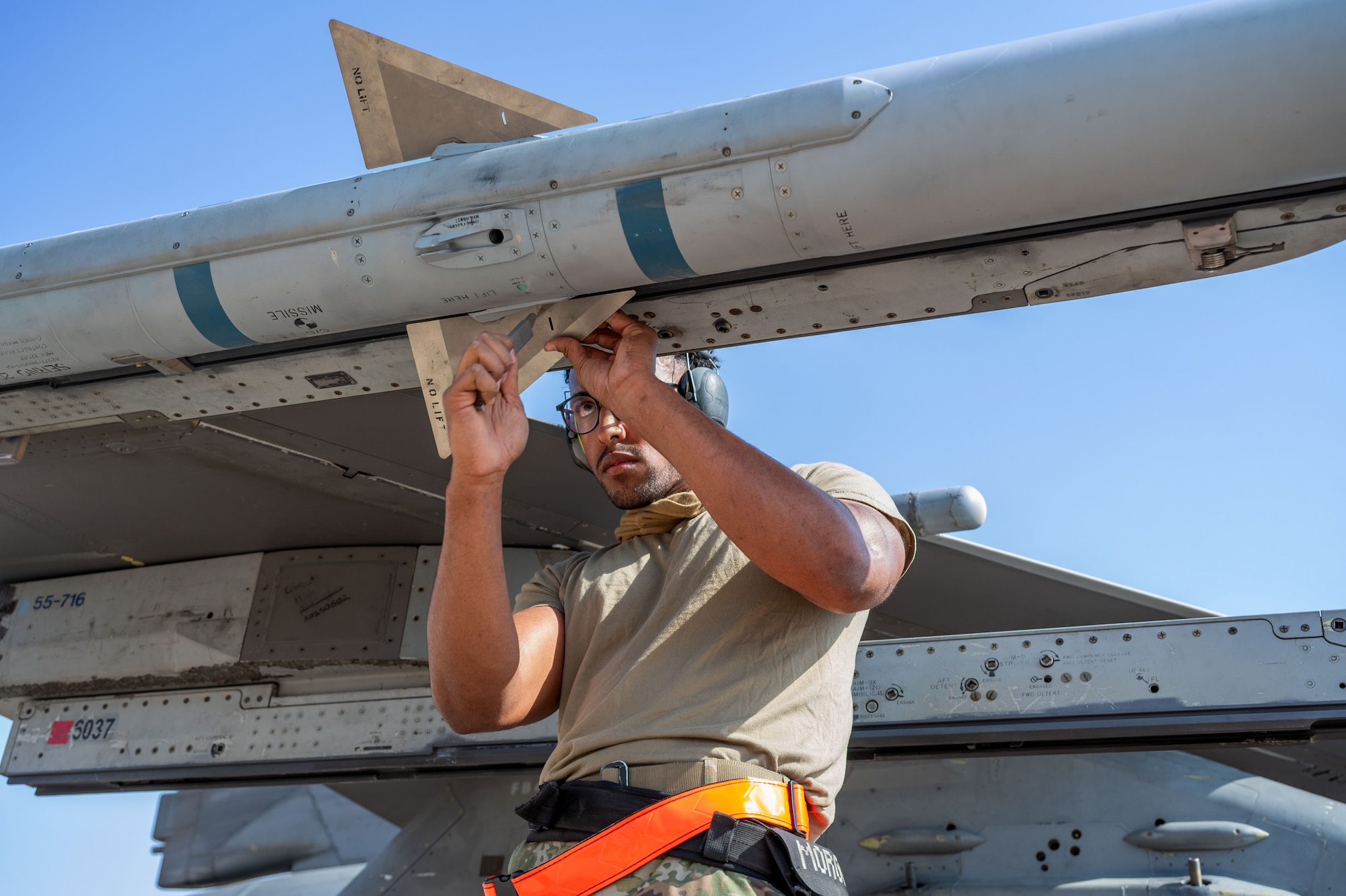 U.S. Air Force Senior Airman Putreal Morgan, 79th Expeditionary Fighter Generation Squadron weapons load crew member, attaches fins to an AIM-120 during a load competition.