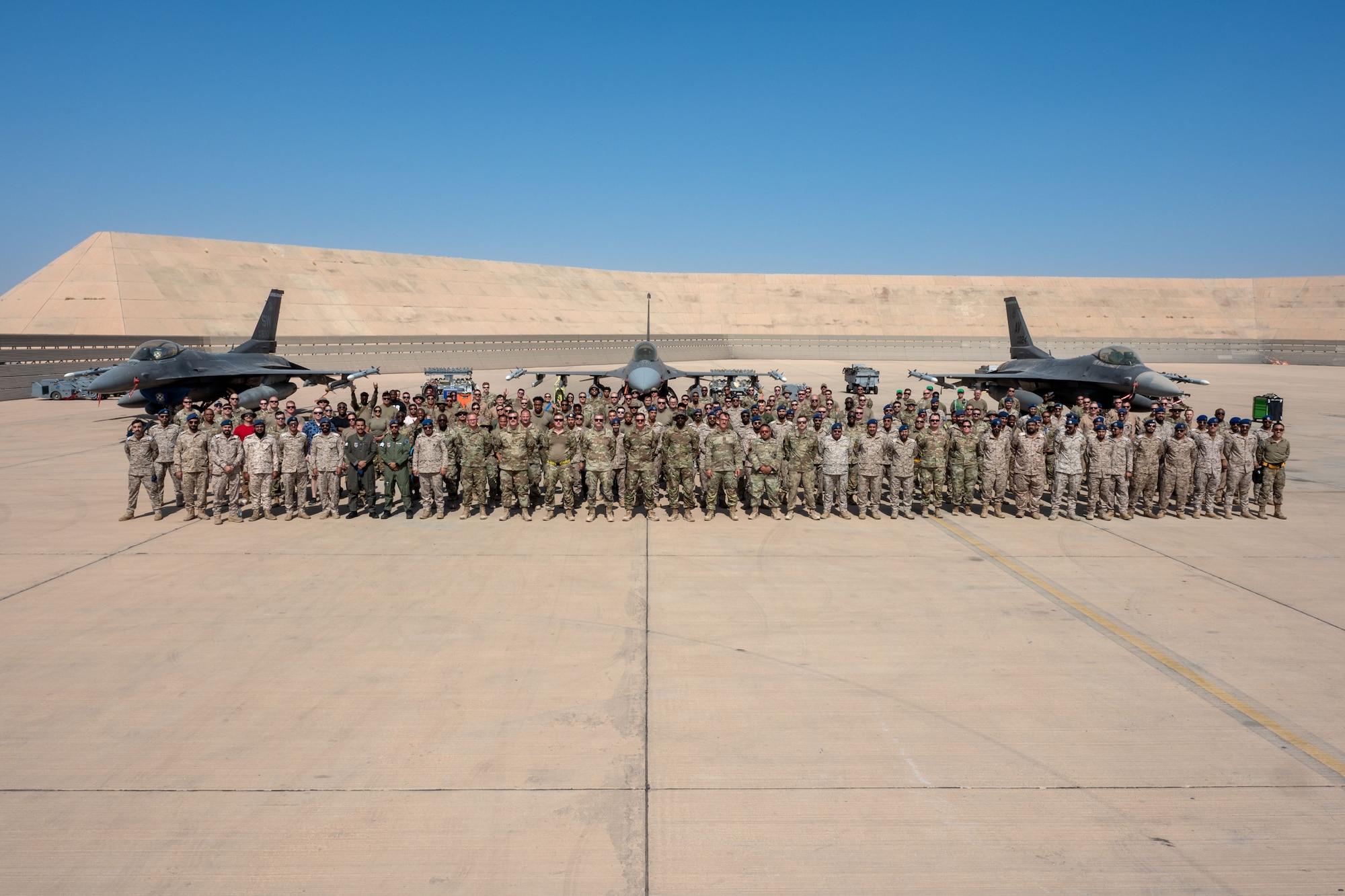 U.S. Airmen and Royal Saudi Air Force service members pose for a photo.