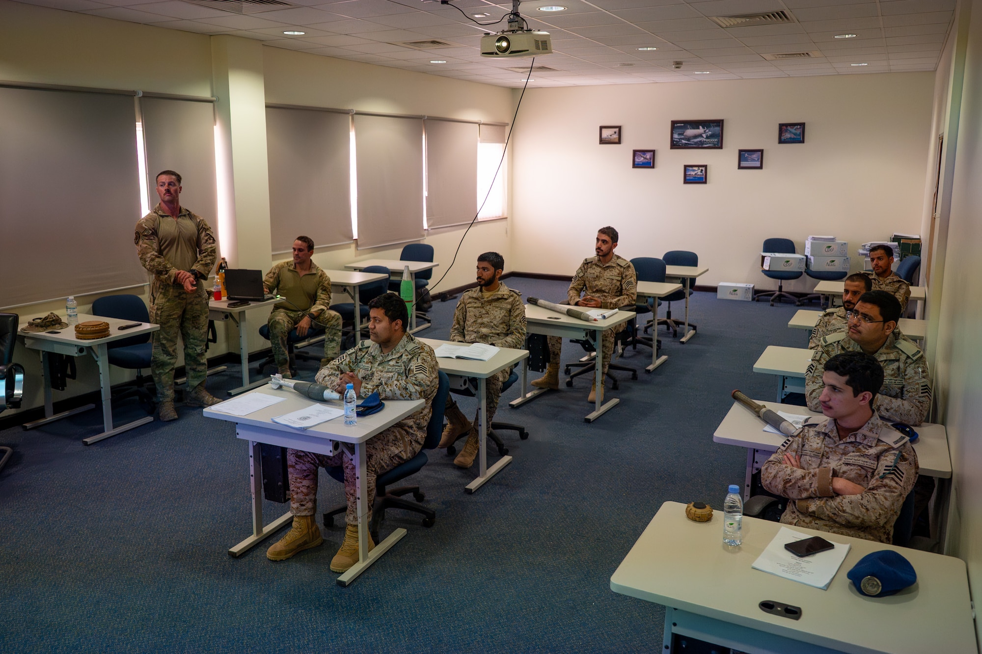 USAF and RSAF service members sit at desks