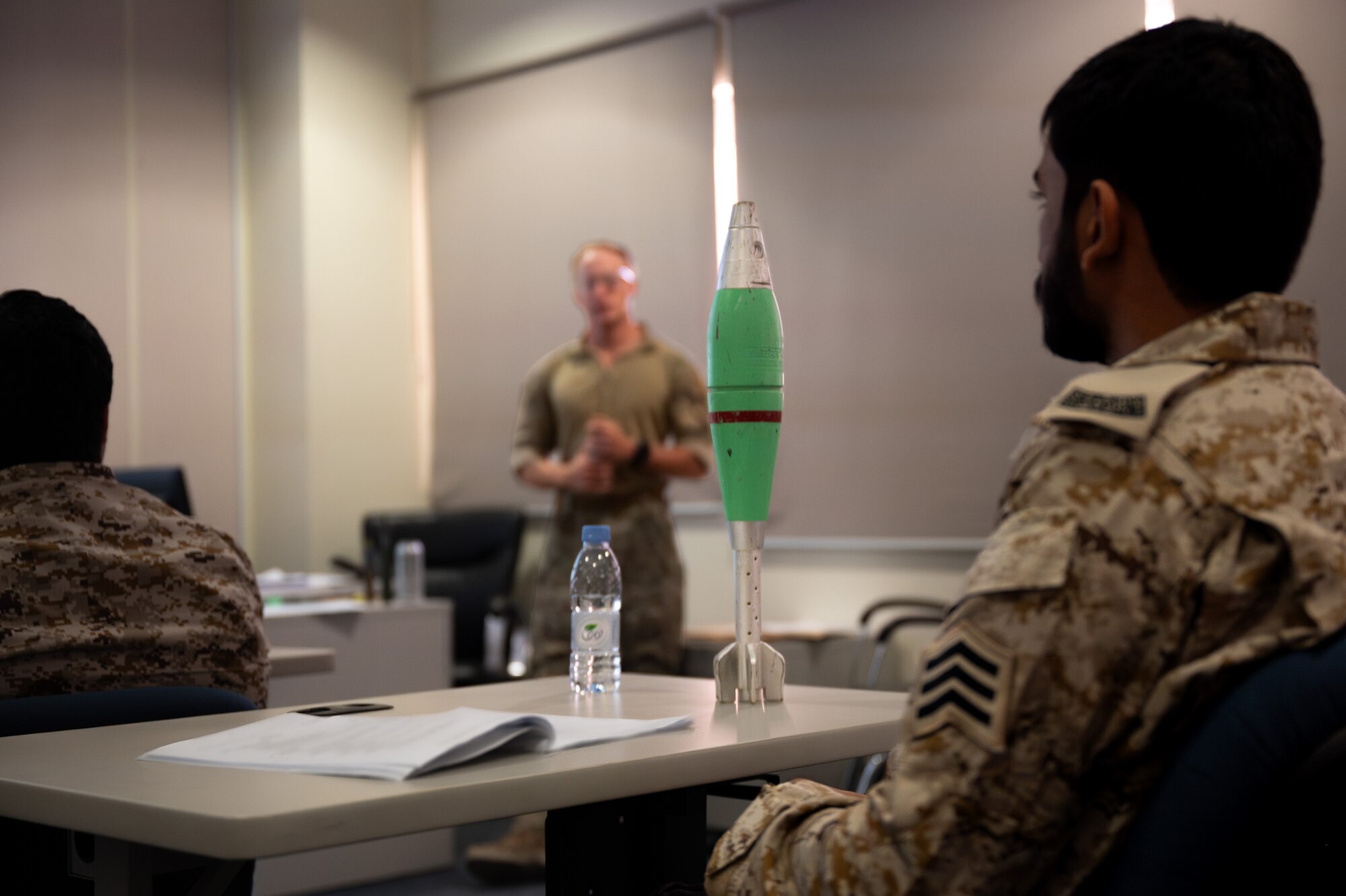 An inert 81mm white phosphorus mortar sits on a desk