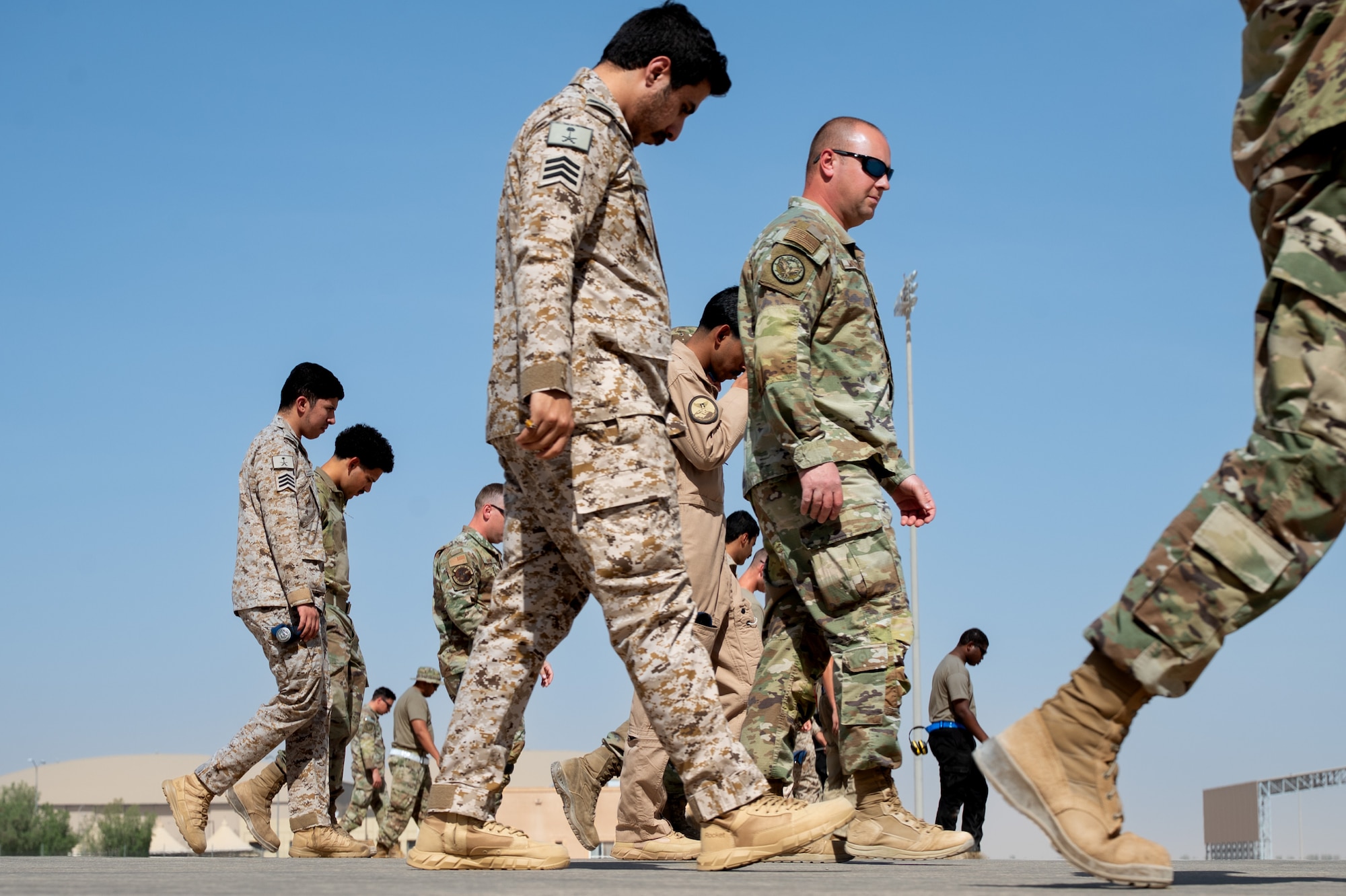 USAF and RSAF service members walk across the flightline