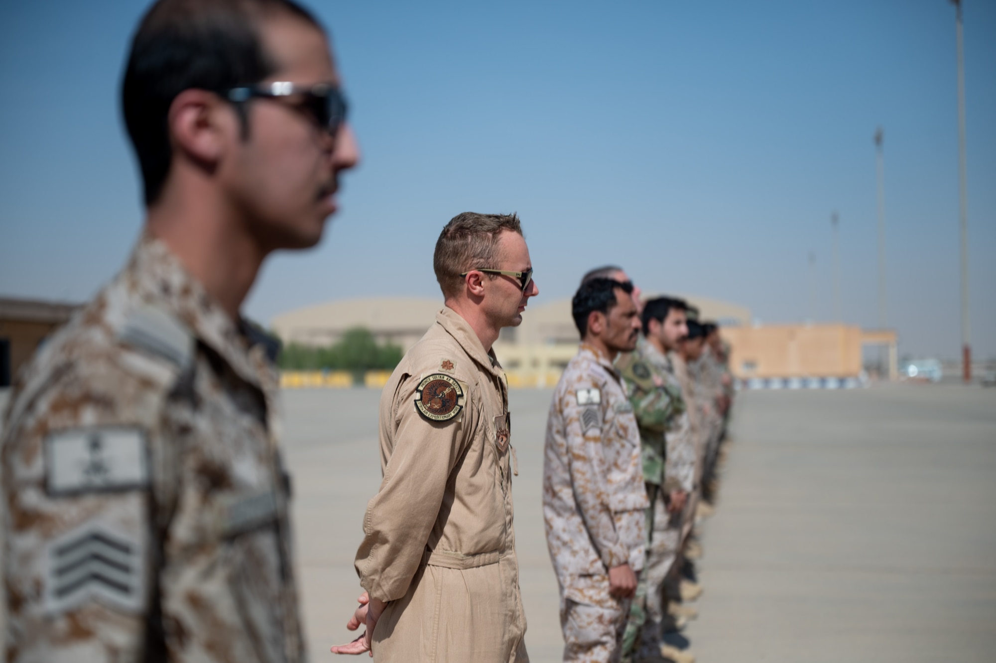 USAF and RSAF service members stand on a flightline