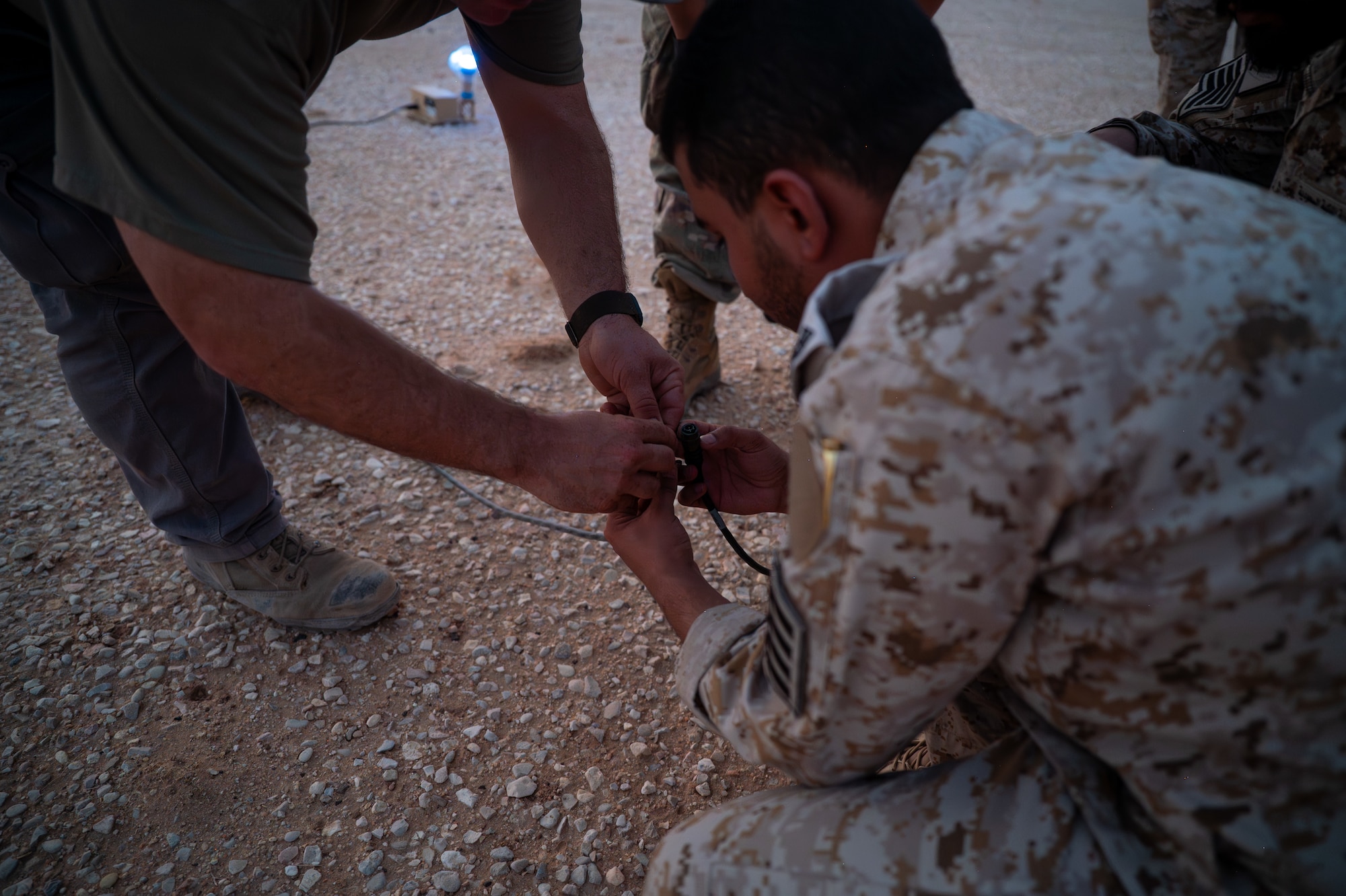 USAF and RSAF service members plug in an expeditionary airfield light