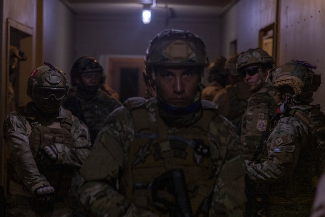 U.S. Marines with 3rd Force Reconnaissance Company, 4th Marine Division,  Infantería de Marina del Perú (Peruvian Naval Infantry), Infantería de Marina de la Armada de la República Argentina (Argentine marines), and Cuerpo de Infantería de Marina (Mexican marine corps), clear a house while participating in a nighttime raid with partner forces during exercise UNITAS 2025 Marine Corps Base Camp Lejeune, North Carolina, Sept. 23, 2025. UNITAS, which is Latin for “unity,” was conceived in 1959 and has taken place annually since first conducted in 1960. This year marks the 66th iteration of the world’s longest running annual multinational maritime exercise. (U.S. Marine Corps photo by Lance Cpl. Payton Goodrich)