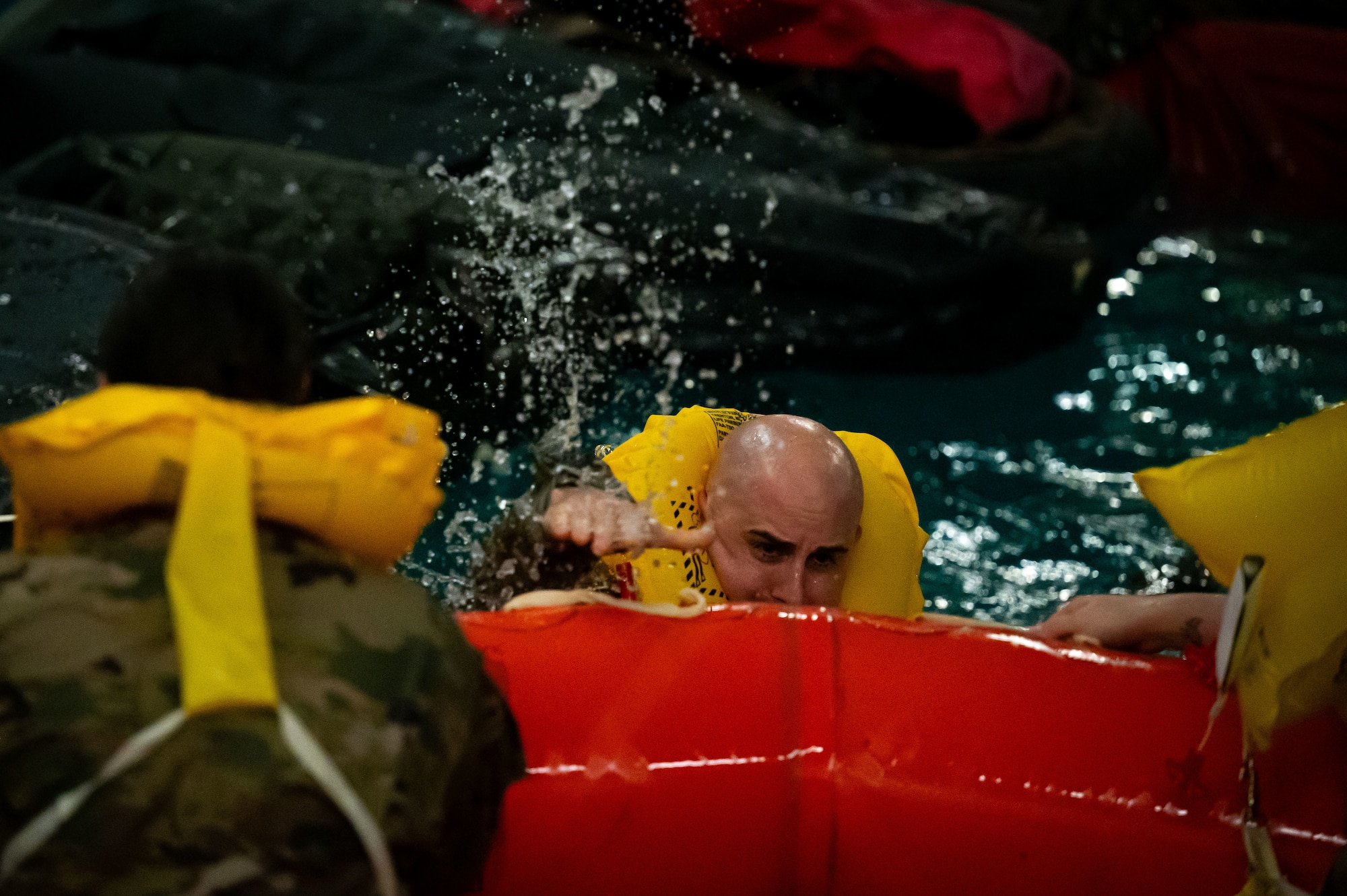 U.S. Air Force Chief Master Sgt. James Wall, 100th Air Refueling Wing command chief, climbs onto a raft during the Survival, Evasion, Resistance, and Escape course at the East Coast Environmental Pool, Lowestoft, United Kingdom, Sept. 12, 2025.