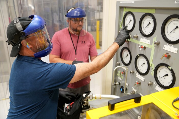 Men working on calibrate machinery