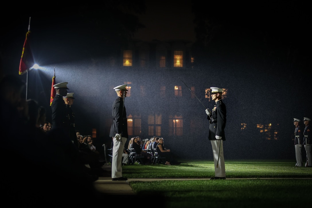 U.S. Marine Corps Capt. Ford Higgins, platoon commander, United States Marine Corps Silent Drill Platoon, Marine Barracks Washington, reports to Maj. Tyler Mach, parade commander for the Evening Parade Staff during the Evening Parade at Marine Barracks Washington, D.C., June 27, 2025. The parade honored Lt. Gen. James H. Adams III, Deputy Commandant for Programs and Resources, as the hosting official. The guests of honor were the Honorable Tom Cole, U.S. Representative from Oklahoma’s Fourth Congressional District, and the Honorable Rosa DeLauro, U.S. Representative from Connecticut’s Third Congressional District. The Evening Parade is a longstanding tradition that showcases the precision and discipline of Marines while honoring distinguished guests. As the Marine Corps approaches its 250th birthday, the ceremony underscores the enduring importance of tradition at the oldest post of the Corps. (U.S. Marine Corps photo by Lance Cpl. Brynn L. Bouchard)