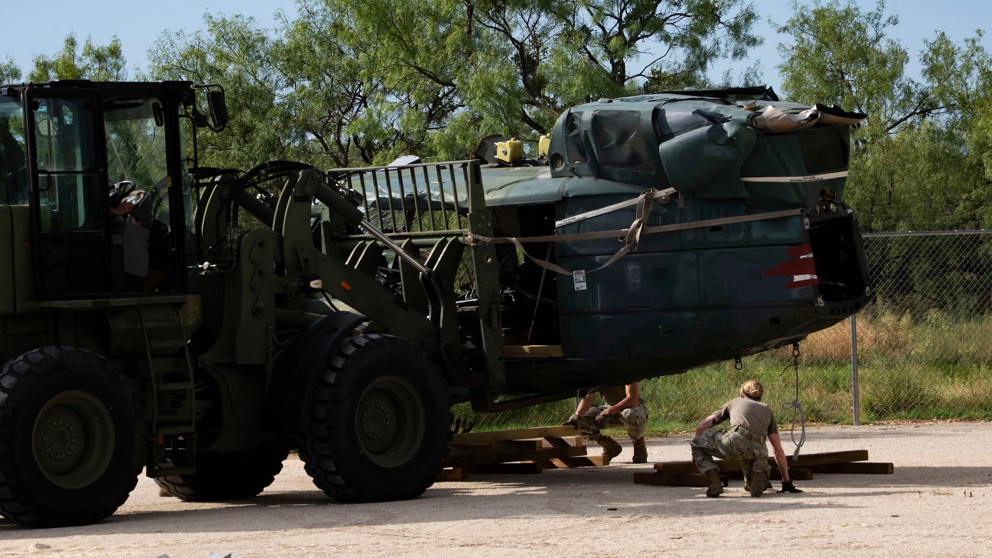 Airmen from the 7th Logistics Readiness Squadron lower a UH-1 Iroquois helicopter at the 436th Training Squadron Aircraft Mishap Investigation Course Crash Lab at Dyess Air Force Base, Texas, September 23, 2025. The 2.5-ton helicopter UH-1 was transported by the 39th Airlift Squadron via C-130J Hercules from Cheyenne Air National Guard Base, Wyoming. (U.S. Air Force photo by Staff Sgt. Tyrell Hall)