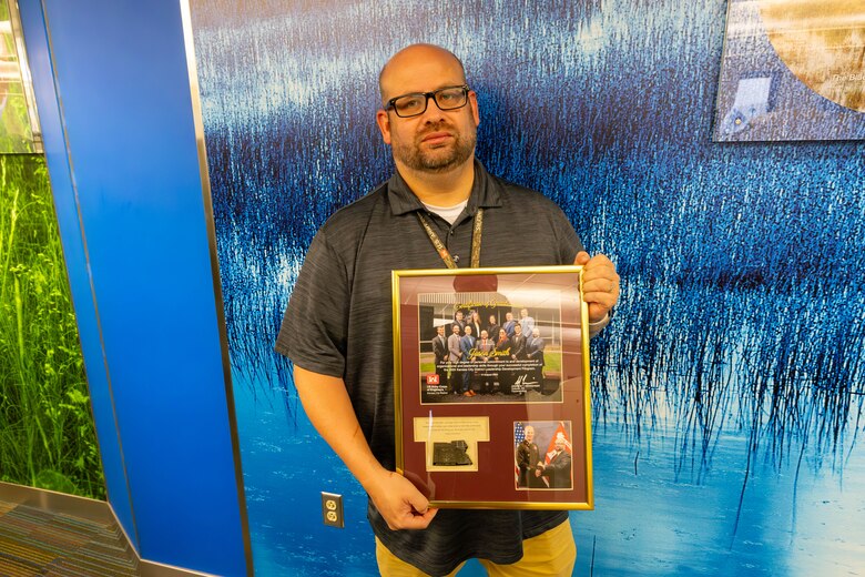 Man standing with plaque.