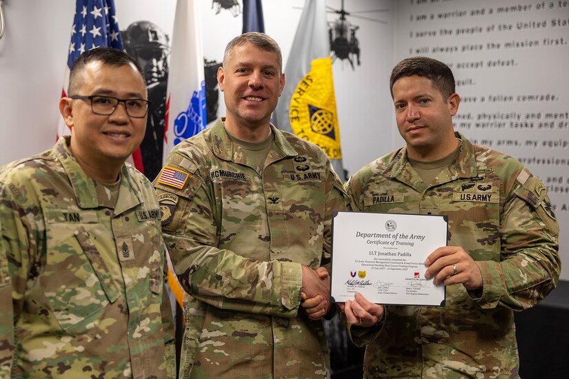 Col. Shaun D. McMurchie, 45th Finance Center director, and Sgt. Maj. Rodani O. Tan, 45th FC senior enlisted advisor, present 1st Lt. Jonathan Padilla, 125th Finance Battalion deputy disbursing officer, with a corticate of training upon completion of the U.S. Army Financial Management Command’s Operational Banking Short Course at the Maj. Gen. Emmett J. Bean Federal Center in Indianapolis Sept. 12, 2025. Upon graduation of the OBSC, Soldiers can advise commanders on establishing financial institutions and ATMs on Army installations, evaluate foreign financial institutions for establishing limited depositary accounts, and provide banking infrastructure evaluations as part of an economic analysis. (U.S. Army photo by Mark R. W. Orders-Woempner)