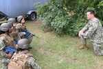 Hospital Corpsman first class Andrew Miller, who recently attained certification as a paramedic-qualified corpsmen, gives trainees a briefing before starting tactical combat casualty care (