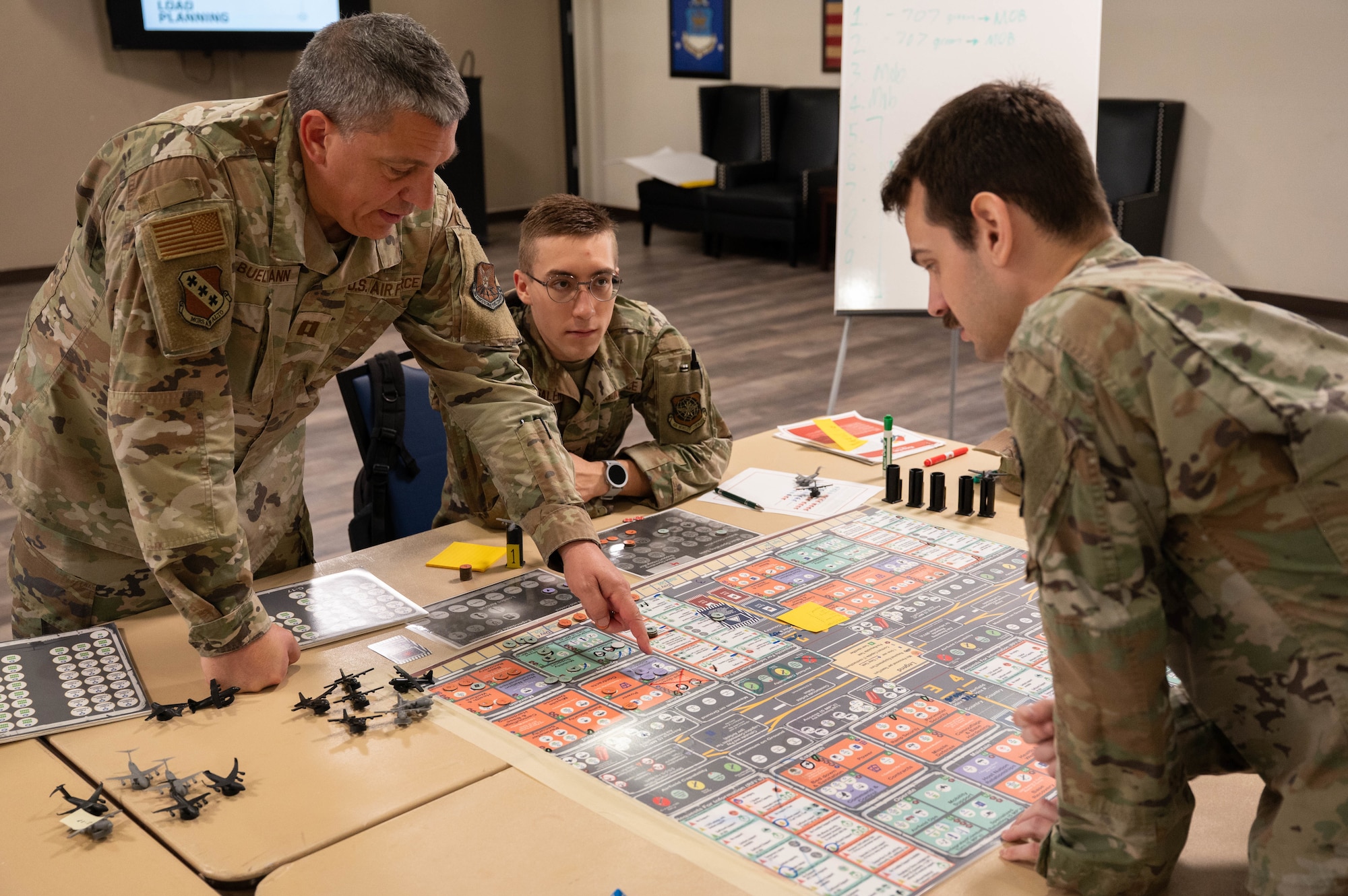 From left, U.S. Air Force Capt. Kurtis Bueltmann, 7th Bomb Wing chaplain, Airman 1st Class Mazen Abusaleh, 317th Airlift Wing technical support specialist, and Senior Airman Bryan Higgason-Sprenkel, 317th Maintenance Squadron aerospace maintenance apprentice, plan moves during a KingFish Agile Combat Employment board wargame exercise at Dyess Air Force Base, Texas, Sept. 16, 2025. This exercise was used to train mission planning, communication and coordination across multiple domains. (U.S. Air Force photo by Airman William Neal)