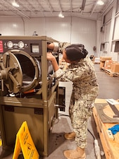 HM2 Nive Hamilton, an NMRLC Biomedical Technician, works on the Automated Field Steam Sterilizer prior to it being transported to Naval Hospital Guantanamo Bay, Cuba, Sept. 19.