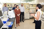 Dr. Erica Molina, a research physiologist assigned to Naval Medical Research Unit (NAMRU) San Antonio’s Cellular and Immune Based Adjuncts (CIBACC) Department, speaks with representatives of DesiCorp, Inc., during a tour of laboratory facilities at the Battlefield Health and Trauma Research Institute.