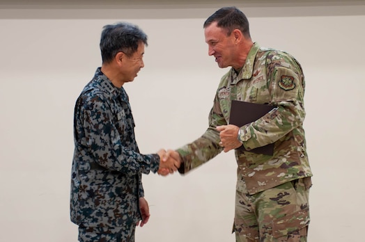  Gen. Johnny Lamontagne, Air Mobility Command commander, right, shakes hands with Lt. Gen. Masahito Yajima, Japan Air Self-Defense Force Air Defense Command commander,