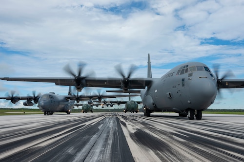 A C-130J Super Hercules assigned to the 19th Airlift Wing, a C-130J-30 Super Hercules assigned to the Royal New Zealand Air Force, a C-130H Super Hercules assigned to the Japan Air Self-Defense Force, and a C-130 Hercules assigned to the South Korea air force prepare for takeoff on the runway.