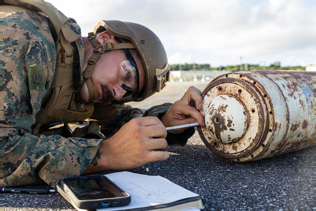 U.S. Marine Corps Staff Sgt. Shawn Gleason, an explosives ordinance disposal technician with Marine Wing Support Squadron 174, Marine Aircraft Group 24, 1st Marine Aircraft Wing measures simulated unexploded ordinance during base recovery after-attack training as part of Resolute Dragon 25 at Marine Corps Air Station Futenma, Okinawa, Japan, Sept. 21, 2025. Resolute Dragon is an annual bilateral exercise in Japan that strengthens the command, control, and multi-domain maneuver capabilities of U.S. Marines in III Marine Expeditionary Force and Japan Self Defense Force personnel, with a focus on controlling and defending key maritime terrain. Gleason is a native of Connecticut. (U.S. Marine Corps photo by Sgt. Gabriel Antwiler)
