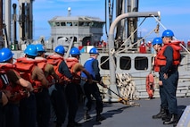 Sailors handle a line on the fo’c’sle of the Arleigh Burke-class guided-missile destroyer USS Curtis Wilbur (DDG 54) during a replenishment at sea with the Republic of Korea’s Cheonji-class fast combat support ship ROKS Daecheong (AOE-58) in support of Freedom Edge 25 at sea, Sept. 17.