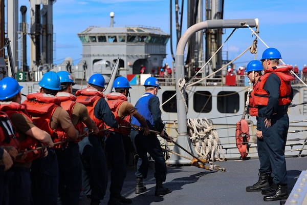 Sailors handle a line on the fo’c’sle of the Arleigh Burke-class guided-missile destroyer USS Curtis Wilbur (DDG 54) during a replenishment at sea with the Republic of Korea’s Cheonji-class fast combat support ship ROKS Daecheong (AOE-58) in support of Freedom Edge 25 at sea, Sept. 17.