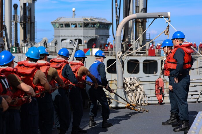 Sailors handle a line on the fo’c’sle of the Arleigh Burke-class guided-missile destroyer USS Curtis Wilbur (DDG 54) during a replenishment at sea with the Republic of Korea’s Cheonji-class fast combat support ship ROKS Daecheong (AOE-58) in support of Freedom Edge 25 at sea, Sept. 17.