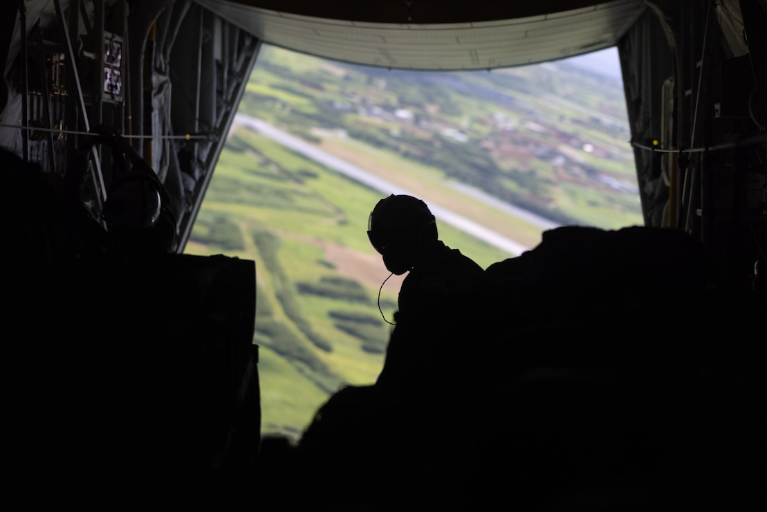 U.S. Marine Corps Cpl. Devin McRae, a loadmaster with Marine Aerial Refueler Transport Squadron 153, Marine Aircraft Group 24, 1st Marine Aircraft Wing, waits for arrival at a drop zone before releasing container delivery systems from a KC-130J Super Hercules during an air delivery operation for Resolute Dragon 25 at Ie Shima, Okinawa, Japan, Sept. 23, 2025.