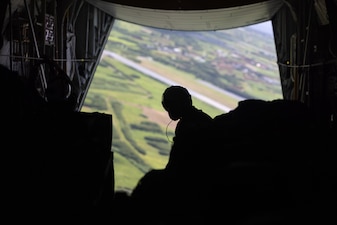U.S. Marine Corps Cpl. Devin McRae, a loadmaster with Marine Aerial Refueler Transport Squadron 153, Marine Aircraft Group 24, 1st Marine Aircraft Wing, waits for arrival at a drop zone before releasing container delivery systems from a KC-130J Super Hercules during an air delivery operation for Resolute Dragon 25 at Ie Shima, Okinawa, Japan, Sept. 23, 2025.