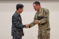 Gen. Johnny Lamontagne, Air Mobility Command commander, right, shakes hands with Lt. Gen. Masahito Yajima, Japan Air Self-Defense Force Air Defense Command commander,