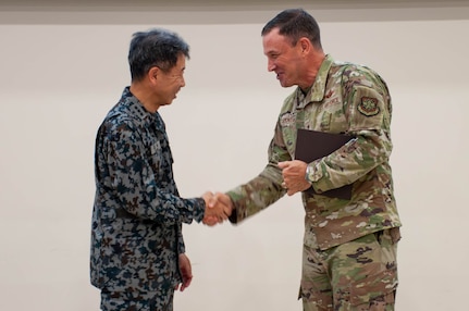 Gen. Johnny Lamontagne, Air Mobility Command commander, right, shakes hands with Lt. Gen. Masahito Yajima, Japan Air Self-Defense Force Air Defense Command commander,