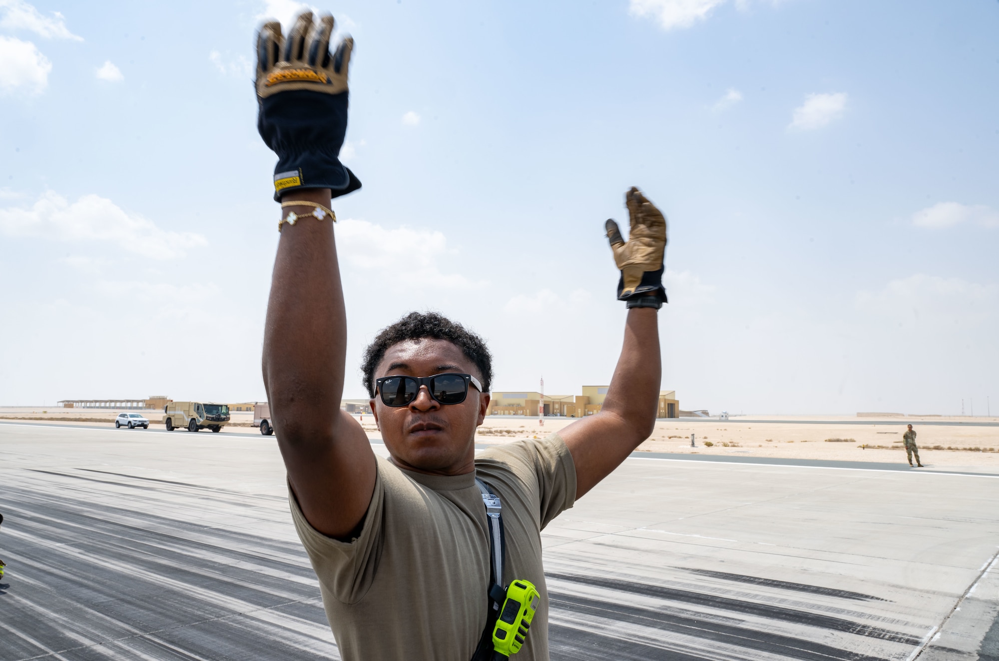 U.S. Air Force Senior Airman Christian Witherspoon, 379th Expeditionary Civil Engineer Squadron crash and recovery firefighter, signals to reset an aircraft arresting system within the U.S. Central Command area of responsibility, Sept. 14, 2025. The aircraft arresting system test provided the 379th ECES Fire and Emergency Services team with an opportunity to sharpen their skills and prepare for aircraft emergencies. (U.S. Air Force photo by Senior Airman Amanda Jett)