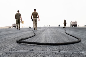 U.S. Airmen assigned to the 379th Expeditionary Civil Engineer Squadron barrier maintenance, take measurements after an arresting system test within the U.S. Central Command area of responsibility, Sept. 14, 2025. The aircraft arresting system is vital for preventing runway overruns during emergency landings or aborted takeoffs, ensuring both the safety of the pilots and aircraft. (U.S. Air Force photo by Senior Airman Amanda Jett)
